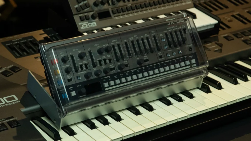 Collezione di strumenti musicali vintage tra sintetizzatori analogici, drum machine e mixer retrò